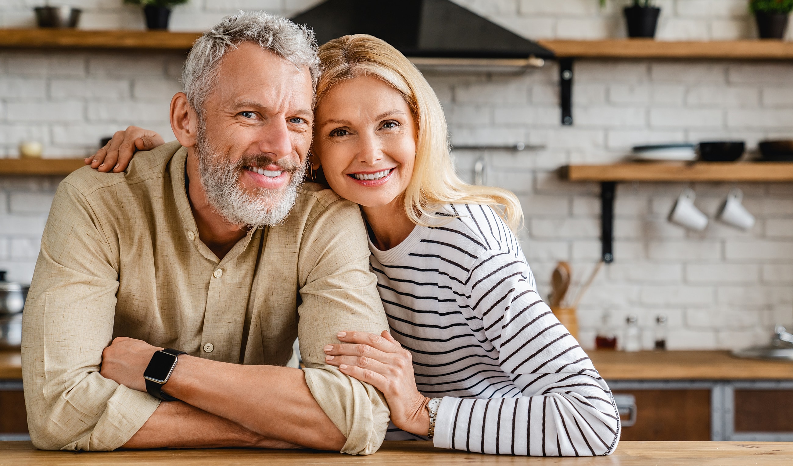 Happy couple posing in a kitchen environment.
